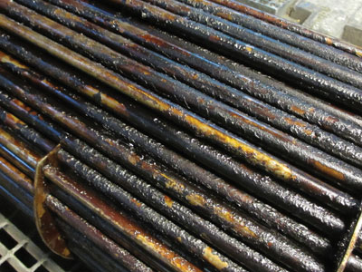 An oil cooler covered by sludge from oil-aging products An oil cooler covered by sludge from oil-aging products