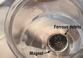 Figure 4. A magnet placed under a gold pan can enable you to observe ferrous debris in a grease sample.