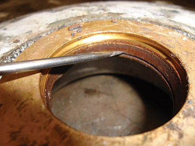 Powder buildup in the motor seal area was caused by clearance in the seal, which was likely due to an over tensioned belt. Once the seal wore out, ingression was inevitable.